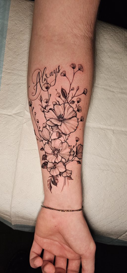 Cluster of flowers with the word Always in script, fine-line tattoo on a forearm